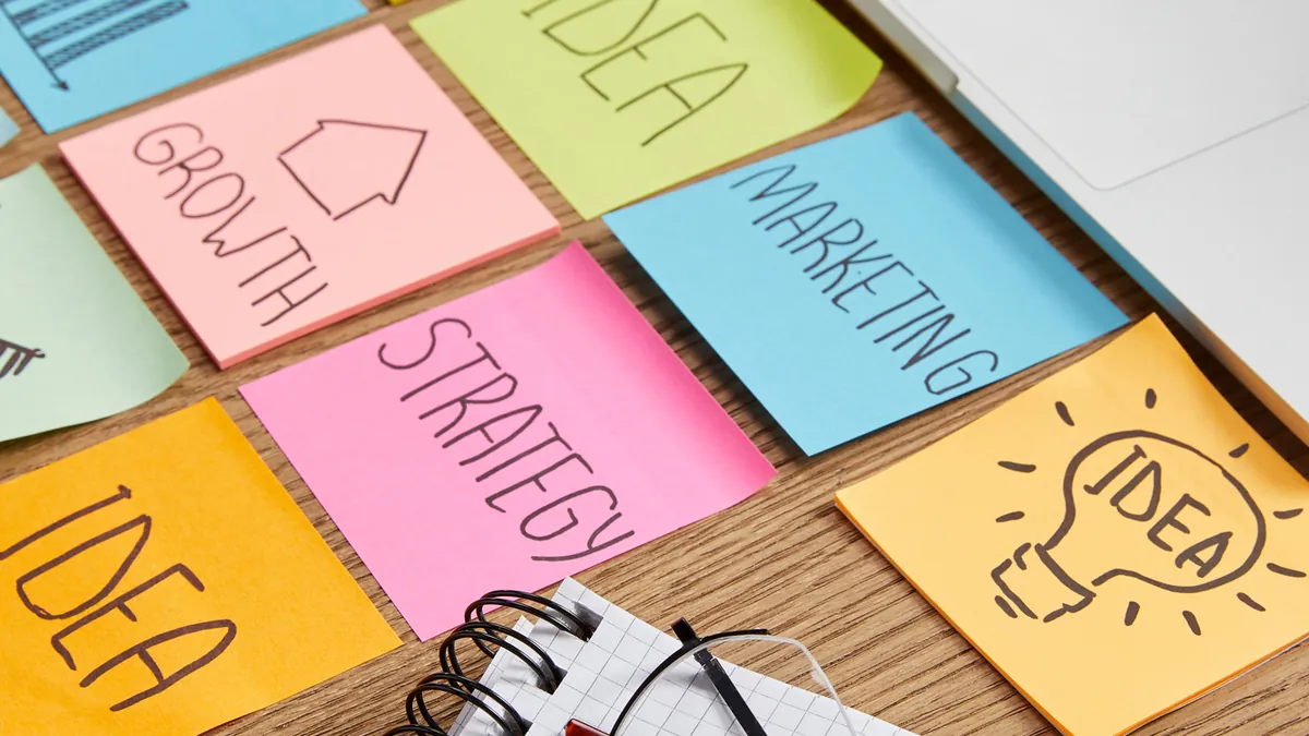 Estrategia de marketing digital: deja de tirar dinero 2 Notas adhesivas de estrategia, ideas y crecimiento sobre la mesa: estrategia de marketing digital para pymes
